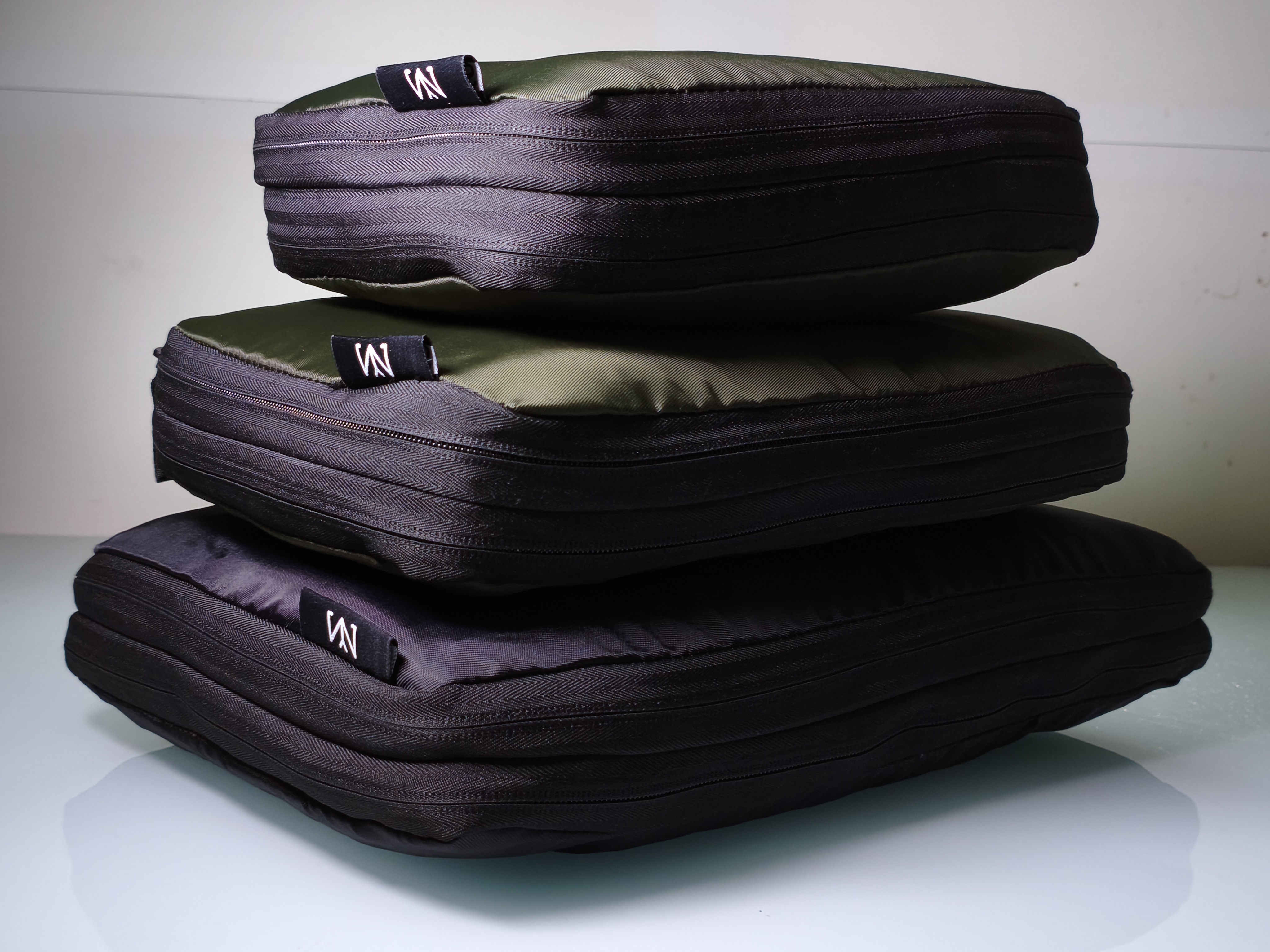 Stacked Swixzelo packing cubes in charcoal and olive